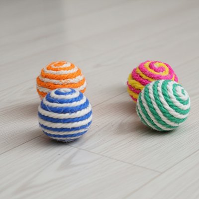 Balle sisal chat : assortiment de quatre balles bicolores en sisal sur un sol clair