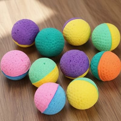 Balle mousse chat : assortiment de balles bicolores texturées sur un parquet