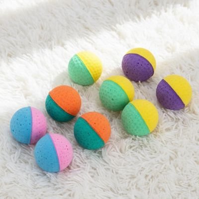 Balle mousse chat : plusieurs balles bicolores disposées sur un tapis blanc